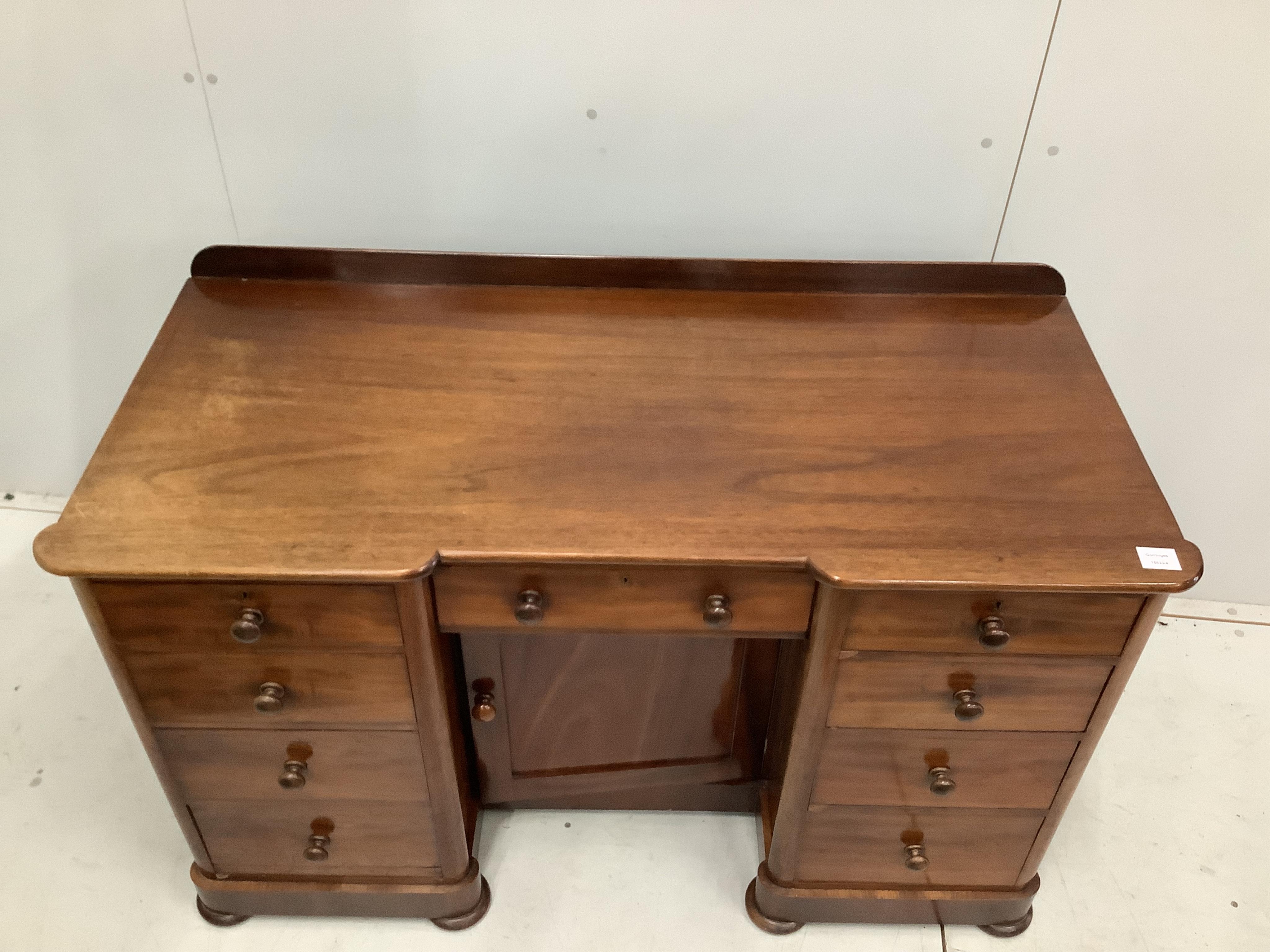 A Victorian mahogany kneehole desk, fitted nine small drawers, width 125cm, height 78cm. Condition - faded to one side, otherwise good